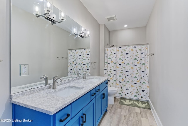 full bathroom featuring a chandelier, wood finished floors, visible vents, and a sink