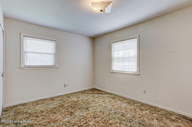 unfurnished room with carpet, a healthy amount of sunlight, and baseboards