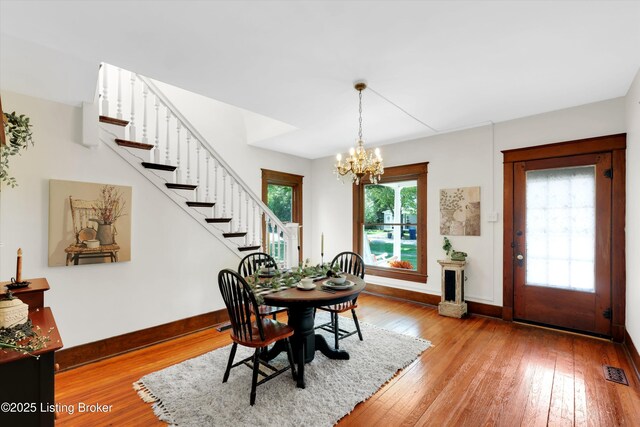 205 Birch Ave, La Grange, KY 40031 - dining area featuring stairway, a chandelier, hardwood / wood-style floors, baseboards, and visible vents