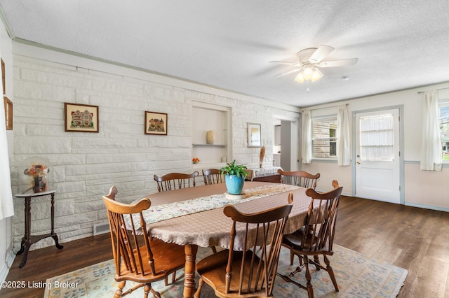 dining space with dark wood-style flooring, a ceiling fan, a textured ceiling, and baseboards