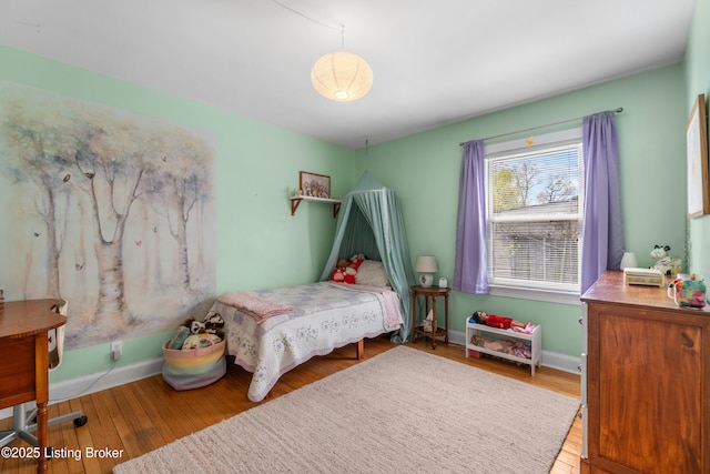 bedroom featuring baseboards and wood finished floors