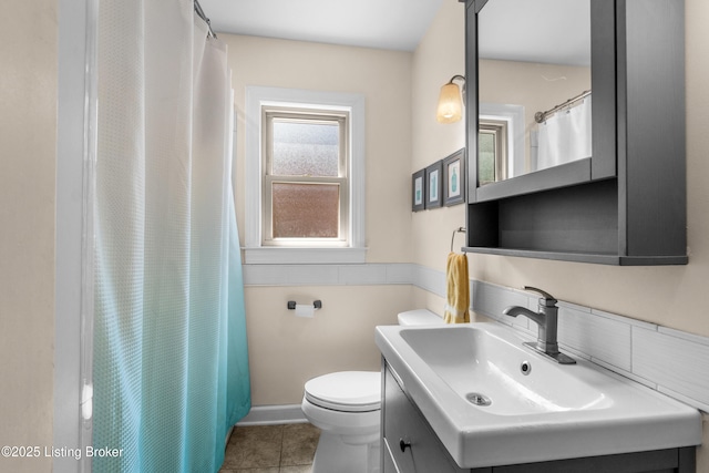 bathroom featuring tile patterned flooring, toilet, vanity, and curtained shower