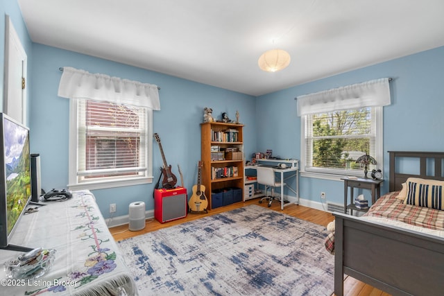 bedroom with wood finished floors and baseboards
