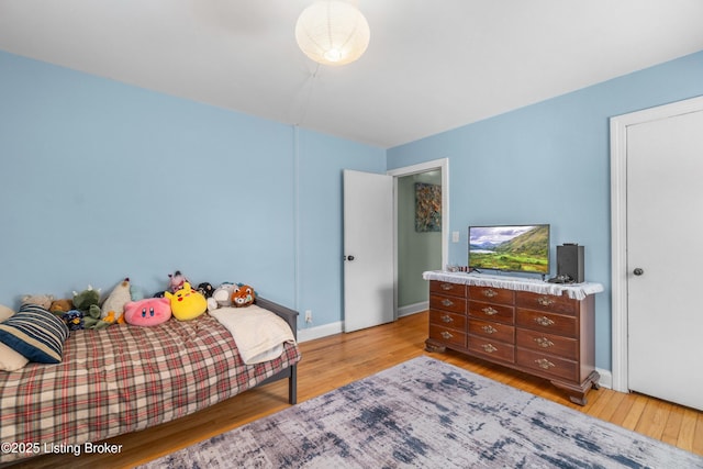 bedroom with baseboards and light wood finished floors