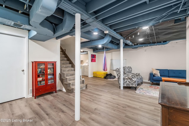 finished basement featuring baseboards, wood finished floors, and stairs