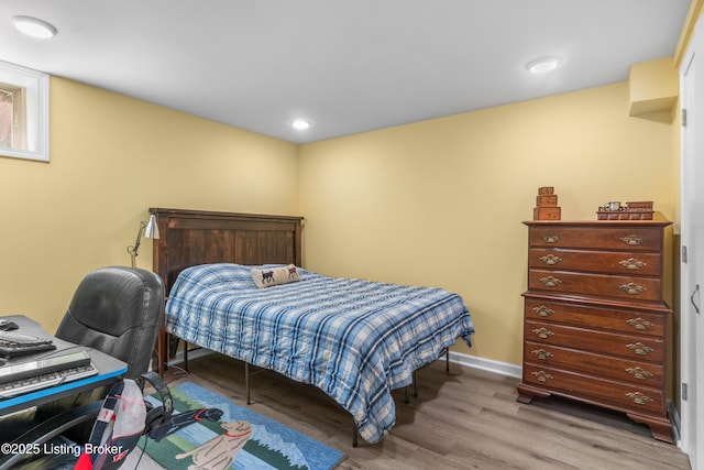 bedroom featuring baseboards, wood finished floors, and recessed lighting