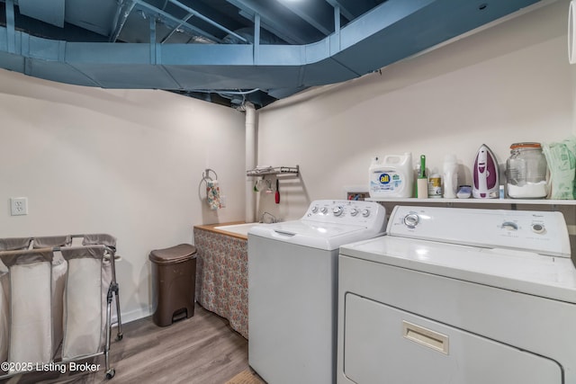 washroom featuring laundry area, washer and dryer, and light wood-style floors