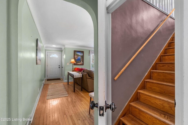 staircase featuring hardwood / wood-style floors, baseboards, and crown molding