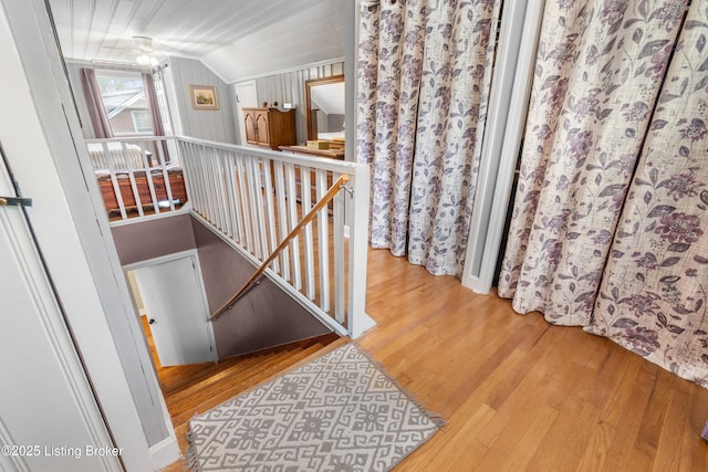 stairs with vaulted ceiling and wood finished floors