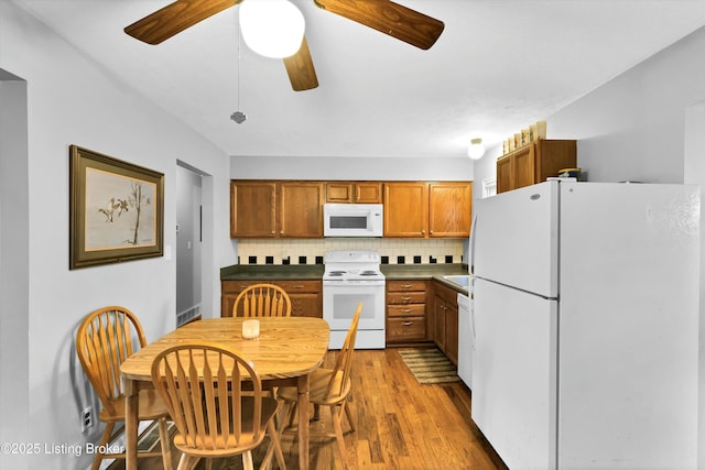 kitchen featuring tasteful backsplash, white appliances, brown cabinetry, ceiling fan, and wood finished floors
