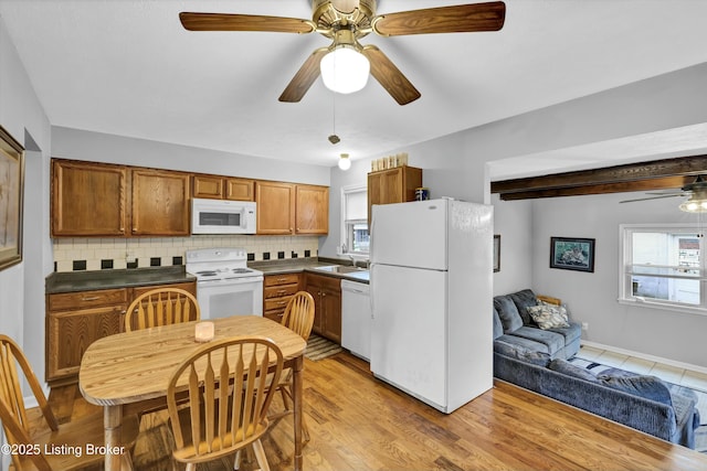 kitchen featuring ceiling fan, white appliances, a sink, dark countertops, and backsplash