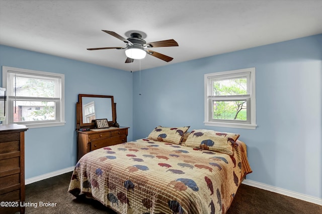 bedroom featuring dark colored carpet, multiple windows, and baseboards