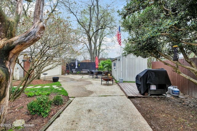 view of patio with grilling area, an outdoor structure, and fence