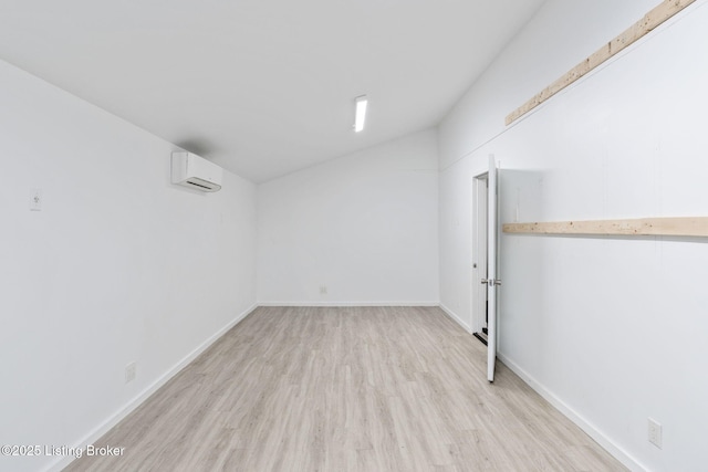 finished basement with baseboards, light wood-type flooring, and a wall mounted air conditioner