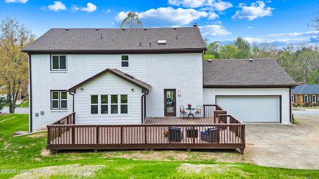 rear view of property with a deck, driveway, brick siding, and a garage