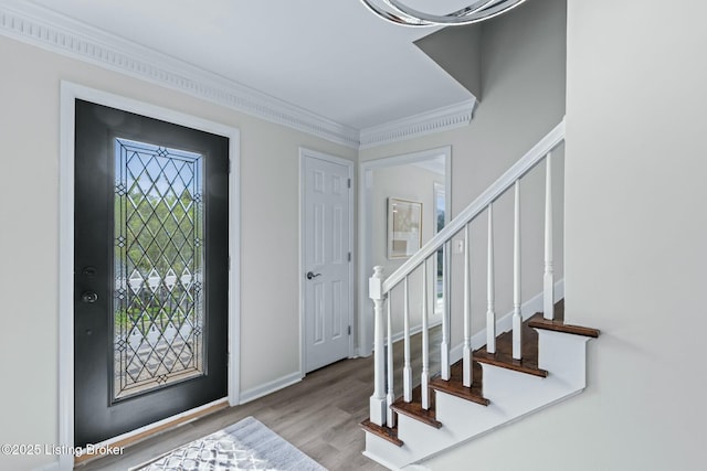 entrance foyer featuring wood finished floors, stairs, and crown molding