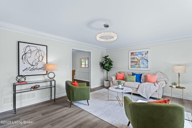 living area featuring baseboards, crown molding, wood finished floors, and visible vents