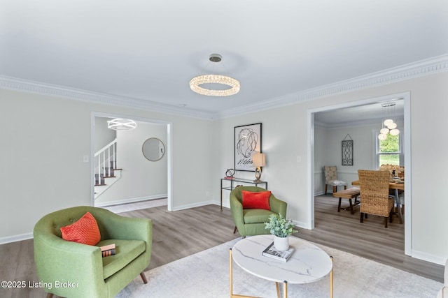 living area featuring baseboards, wood finished floors, stairs, and ornamental molding