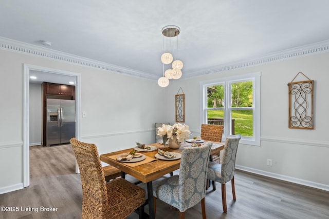 dining room with baseboards, crown molding, and wood finished floors