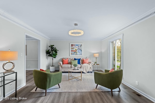 living room featuring baseboards, wood finished floors, visible vents, and ornamental molding