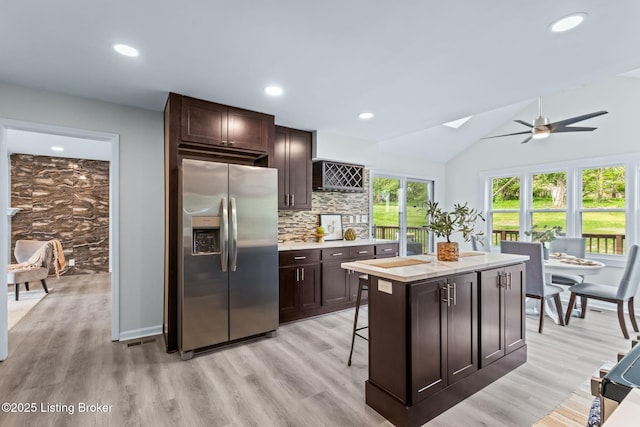 kitchen with ceiling fan, dark brown cabinetry, light countertops, and stainless steel fridge
