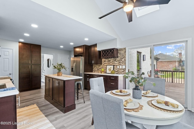 dining room with recessed lighting, light wood-style flooring, high vaulted ceiling, and ceiling fan