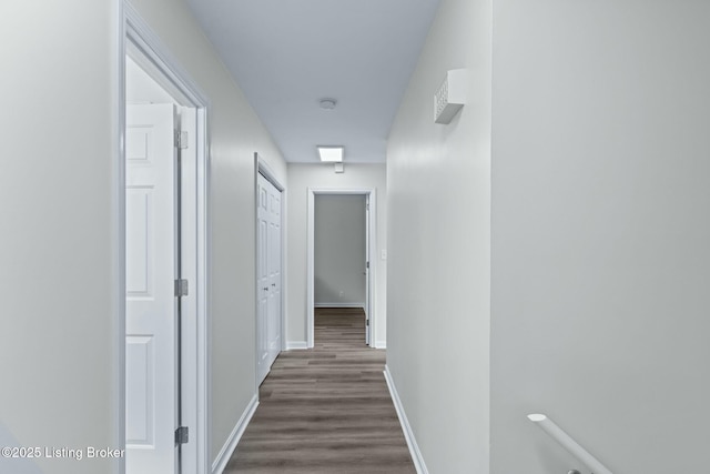 hall with baseboards and dark wood-style flooring