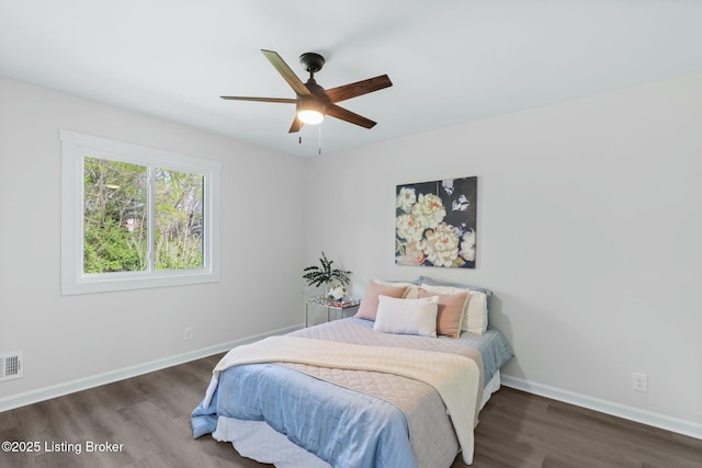 bedroom with wood finished floors, visible vents, baseboards, and ceiling fan