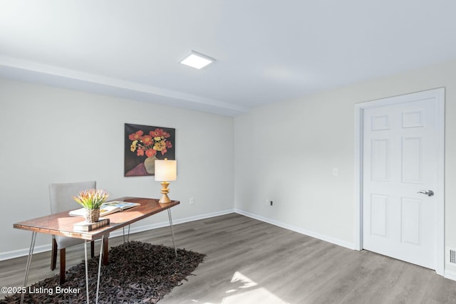 unfurnished office featuring wood finished floors and baseboards