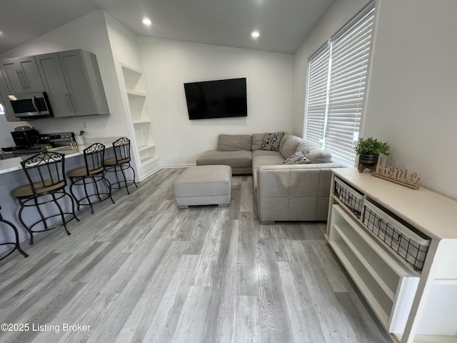living area featuring recessed lighting, lofted ceiling, and light wood-type flooring