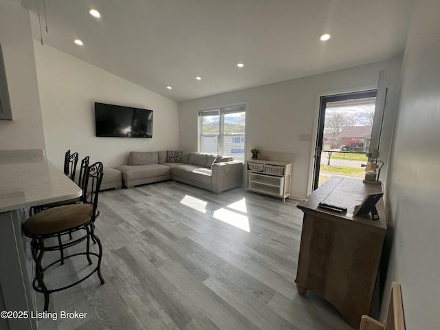 living area with recessed lighting, light wood-style flooring, and lofted ceiling
