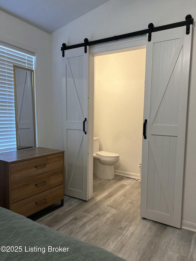 bathroom featuring wood finished floors, toilet, and baseboards