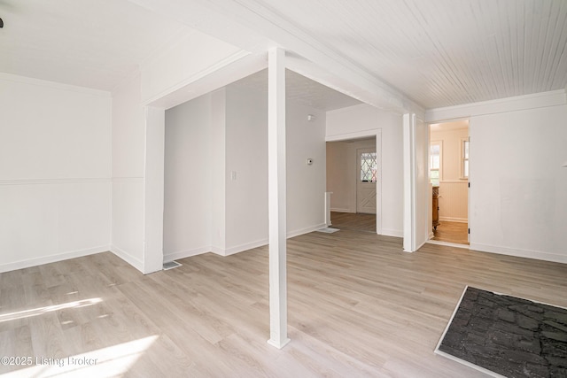 interior space with baseboards, ornamental molding, visible vents, and light wood-style flooring
