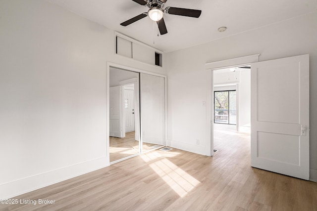 unfurnished bedroom featuring ceiling fan, baseboards, a closet, and light wood-type flooring
