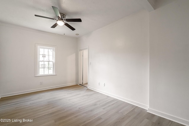 unfurnished room featuring wood finished floors, baseboards, and ceiling fan