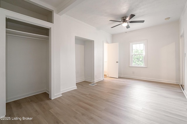 unfurnished bedroom with light wood finished floors, baseboards, visible vents, a closet, and ceiling fan