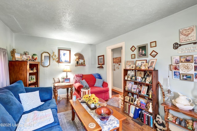 living area with wood finished floors and a textured ceiling
