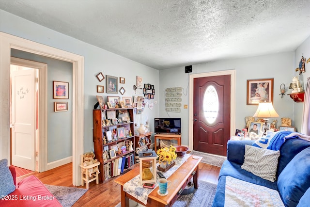 living area featuring light wood-type flooring and a textured ceiling