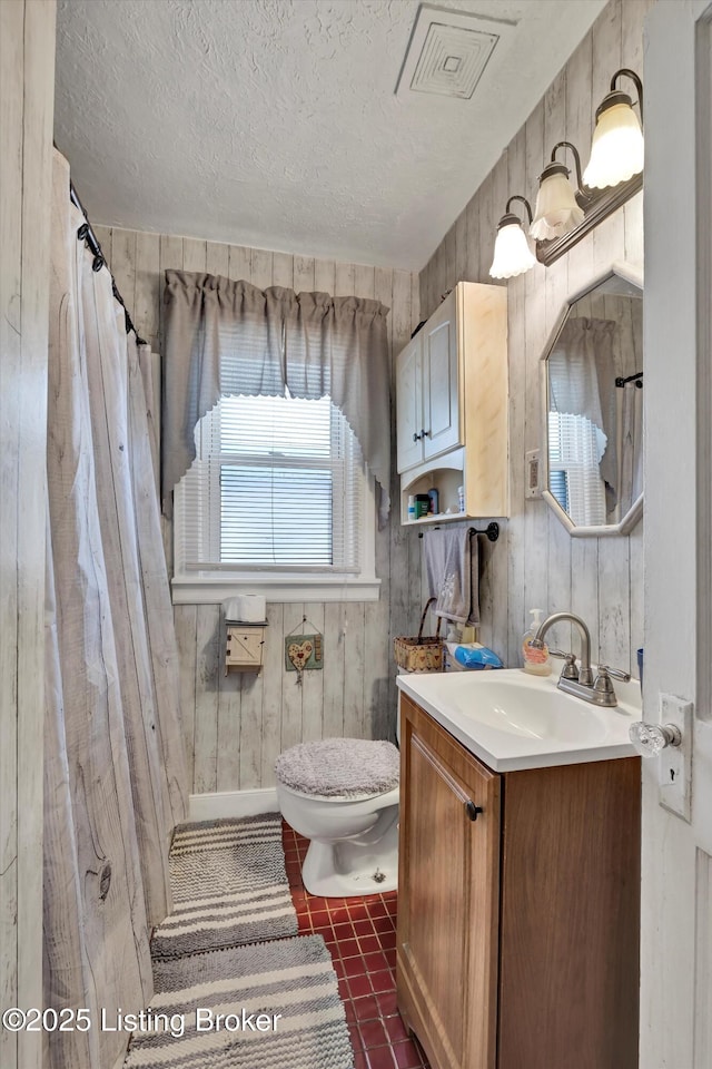full bathroom featuring a textured ceiling, vanity, toilet, tile patterned flooring, and visible vents