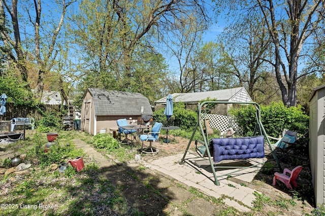 view of yard featuring fence, a shed, an outbuilding, a patio, and a gazebo