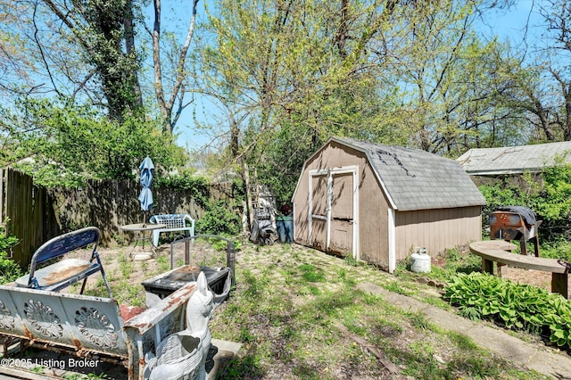 view of yard with an outdoor structure, fence, and a storage shed