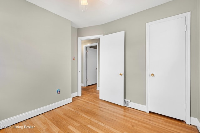 unfurnished bedroom featuring light wood-style floors, baseboards, visible vents, and a ceiling fan