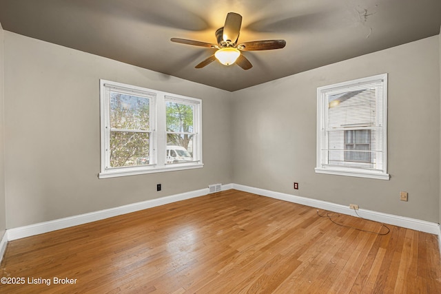 empty room featuring light wood-style floors, ceiling fan, baseboards, and visible vents