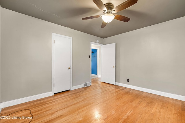 empty room with visible vents, baseboards, a ceiling fan, and wood finished floors