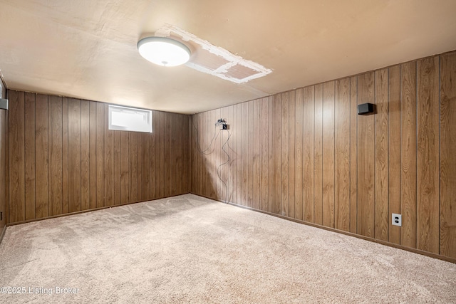 below grade area featuring wood walls and carpet flooring