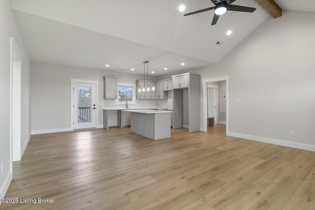kitchen featuring open floor plan, light countertops, a ceiling fan, recessed lighting, and a kitchen island