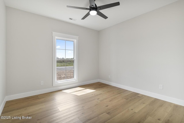 empty room with wood finished floors, baseboards, and a ceiling fan