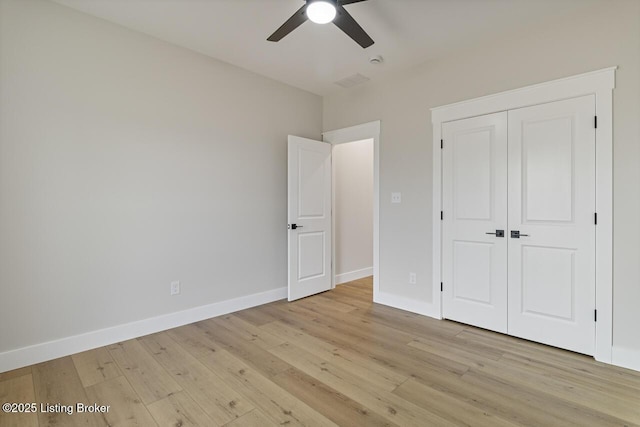 unfurnished bedroom with a closet, baseboards, ceiling fan, and light wood-style floors