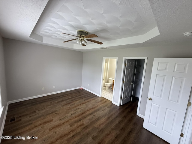 7213 Hassock Dr, Louisville, KY 40258 - unfurnished bedroom featuring dark wood-type flooring, a spacious closet, visible vents, a raised ceiling, and baseboards