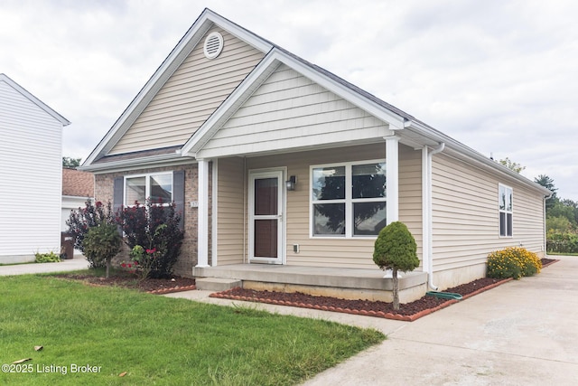 bungalow-style home with a front yard and concrete driveway